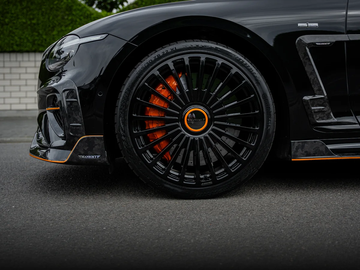 Schwarze MANSORY Felge in 22 Zoll mit orangem Bremssattel