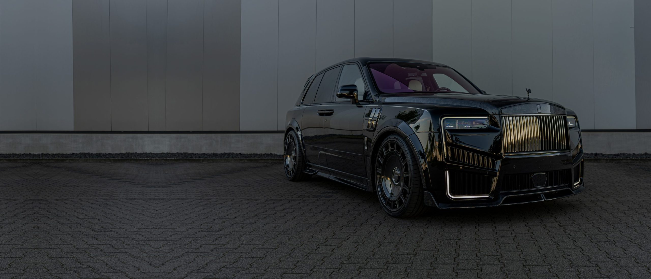 Schwarzer Rolls-Royce Cullinan vor dem Betriebsgebäude