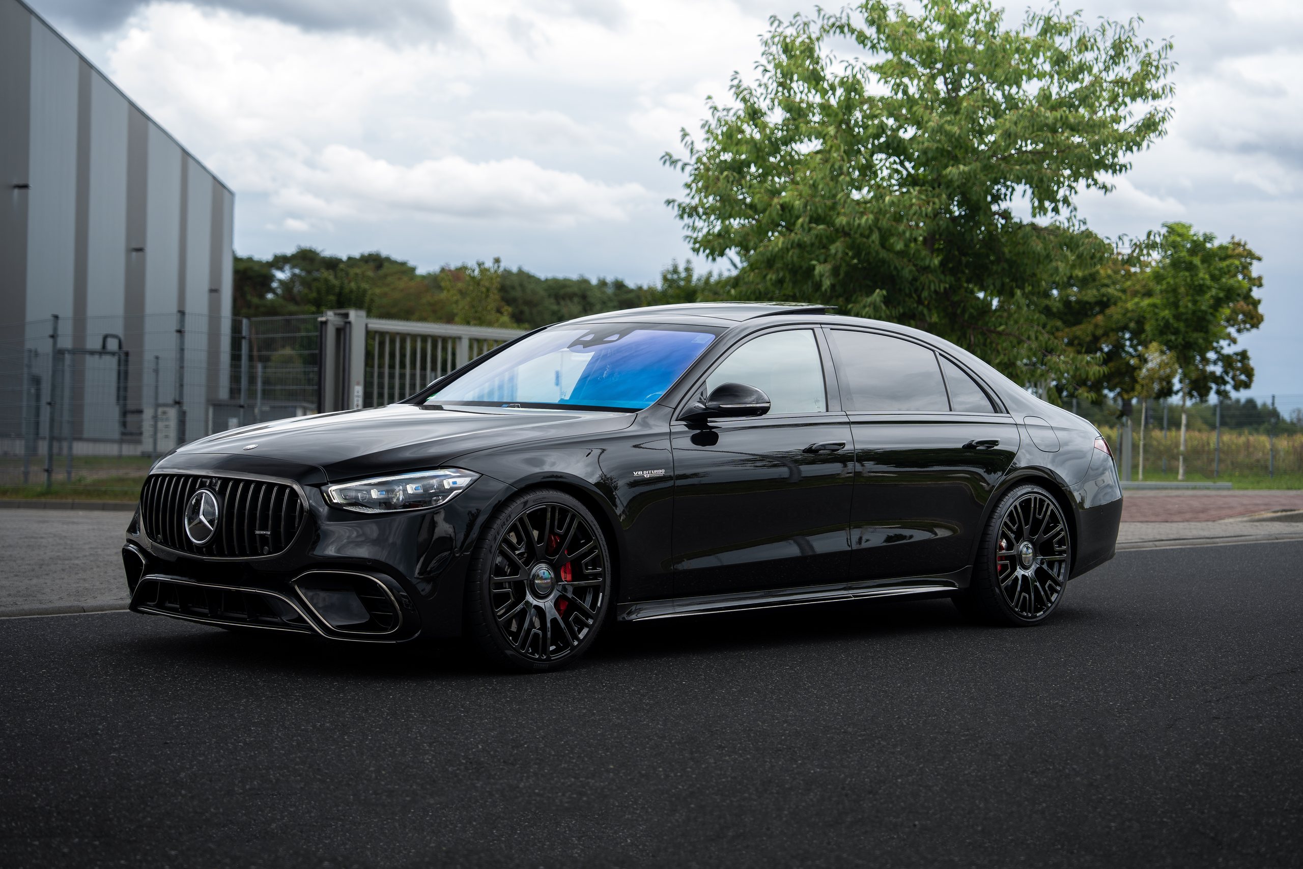 Veredelte Mercedes-AMG S-Klasse in Schwarz vor einer Halle